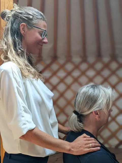 Hester begeleidt een deelnemer met een hand op de schouder